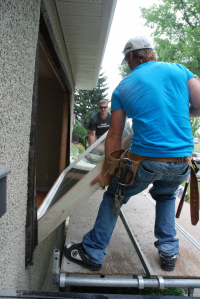 Workers replace old windows in a home energy retrofit. 