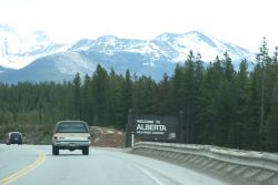 A truck passes the sign that marks the entrance into Alberta from B.C.