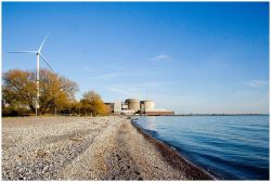 A wind turbine stands on the shore near the nuclear power plant in Pickering, Ont. 