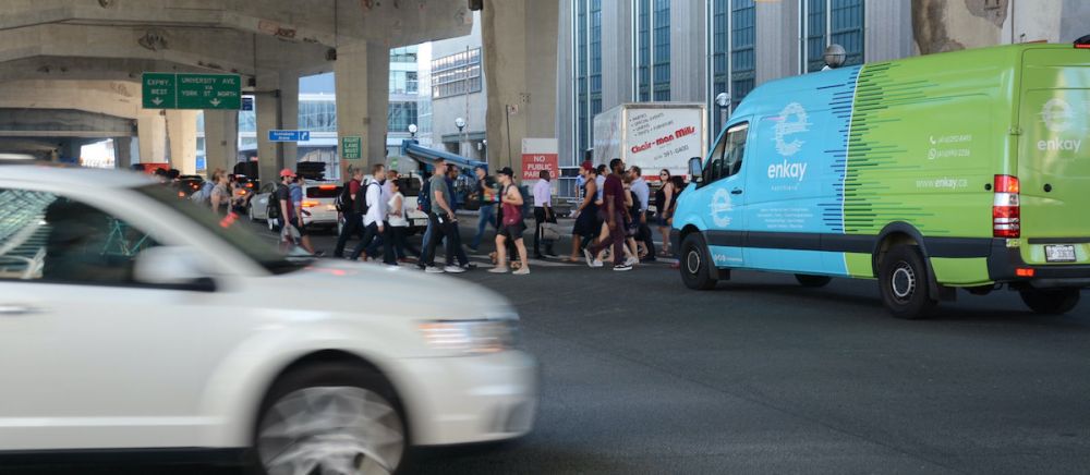 Busy street scene with delivery vehicles, pedestrians and cars