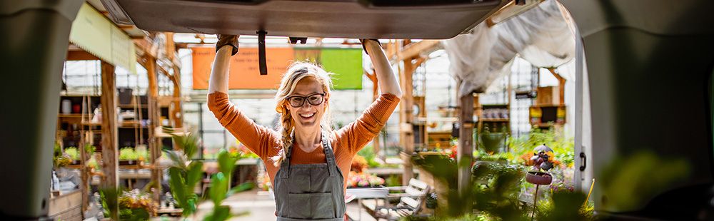 Woman opening cargo van door with plants