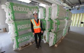 * Adrienne Lynn, sustainable innovations specialist with Clark Builders stands by carefully stacked insulation that sits on pallets, all part of keeping it clean and green on LEED projects. Photo David Dodge, Green Energy Futures