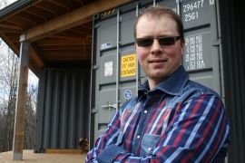 * Jason Rioux at the end of the recreation room in his sea container cabin near Bobcaygeon, Ontario. The cabin locks up very securely thanks to the original shipping container doors that close over sliding patio doors.