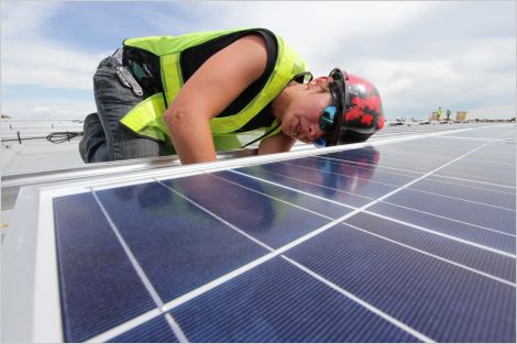 Worker installing solar panel