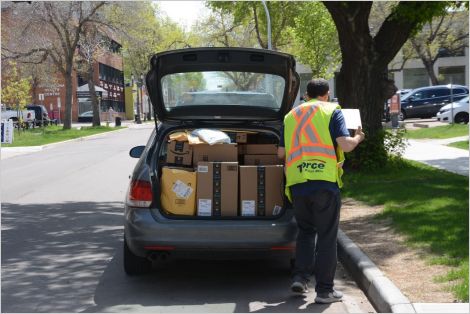 worker unloading parcels from delivery vehicle in Edmonton