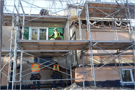 Workers retrofitting a residential building