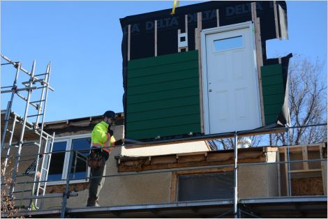 Workers retrofitting a residential building