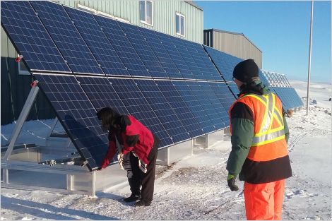 Ground-mounted solar installation in Arctic with two people