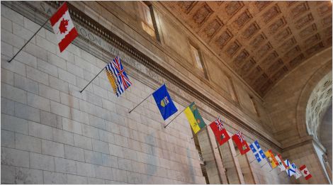 Canada's federal and provincial flags hanging in Union Station, Toronto