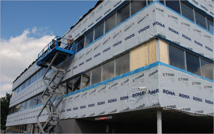 commercial building retrofit with worker on scaffold