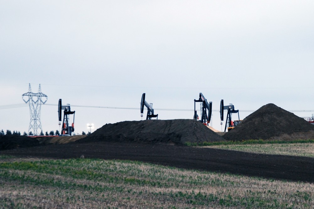 Pumpjacks on oil site with electricity transmission in background