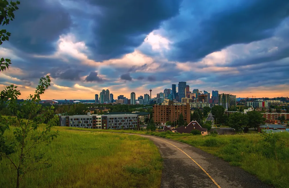 Cloudy Sunrise Sky Over A Park Road Leading Towards Downtown Calgary