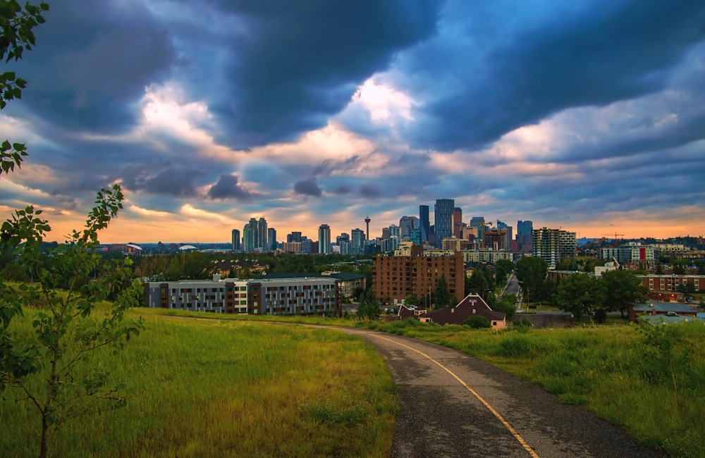 Cloudy Sunrise Sky Over A Park Road Leading Towards Downtown Calgary