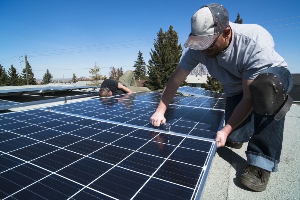 Workers installing solar panels on a residential homes roof
