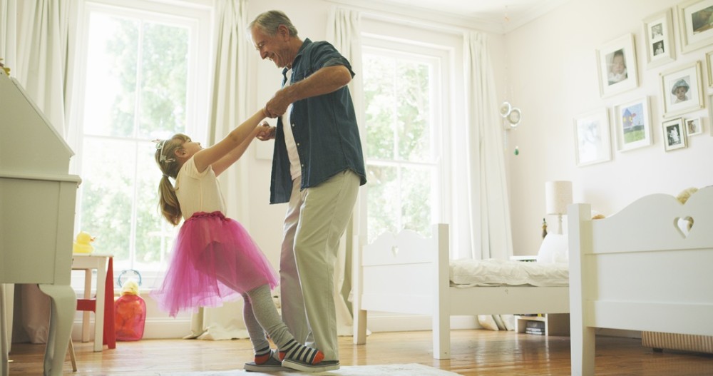 Intergenerational family dancing in bedroom