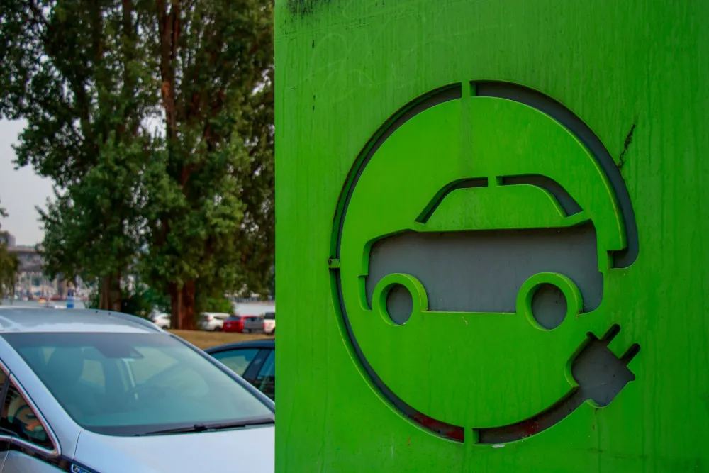 A close-up picture of a green electric vehicle charging station sign