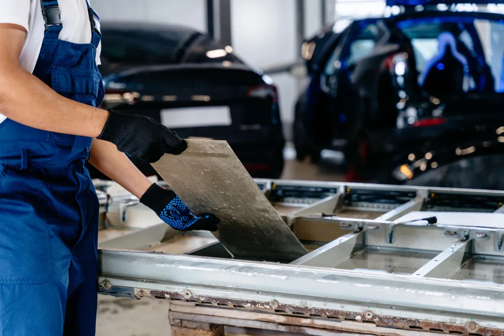 EV engineer working with car battery module in workshop