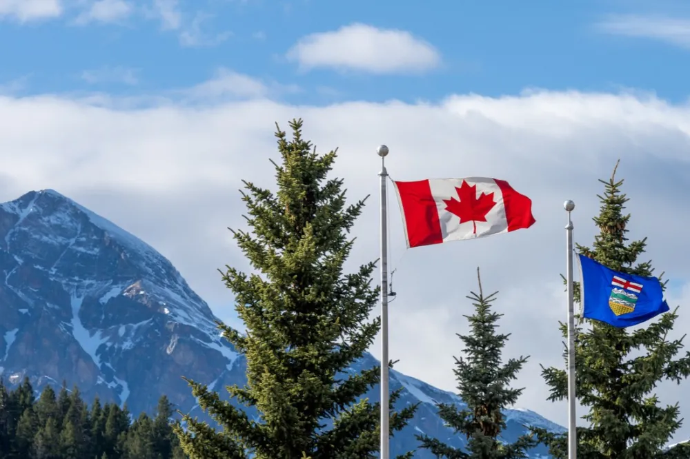 The flag of Canada and flag of Alberta, with mountains