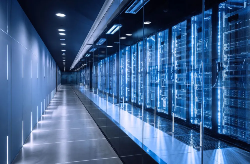 A horizontal, wide shot of a futuristic data center corridor with rows of server racks and control panels. 