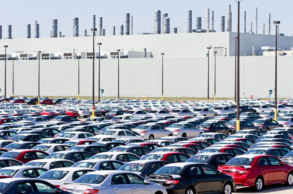 Rows of cars filling the parking lot at an auto assembly plant
