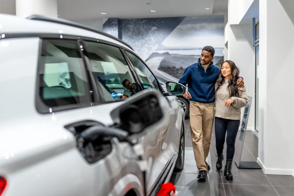 Couple looks at EV car at dealership