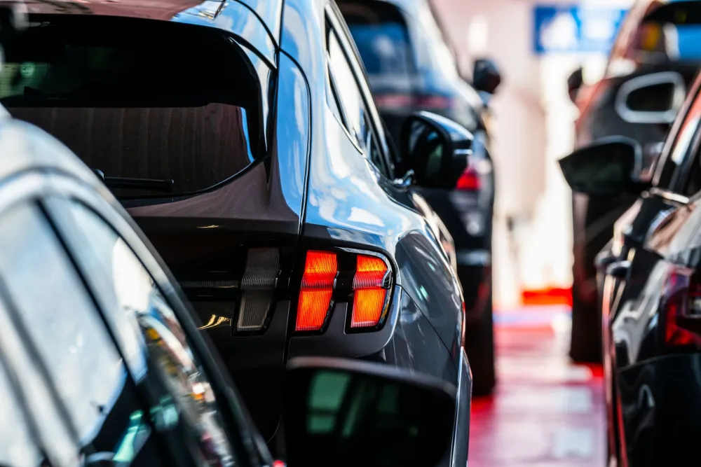 Close-up of a Ford Mach-E rear light, with rows of parked vehicles in the background on a ferry