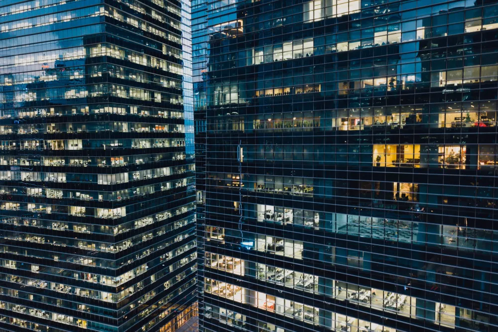 Nighttime scene of downtown skyscrapers with several empty offices (lights off)