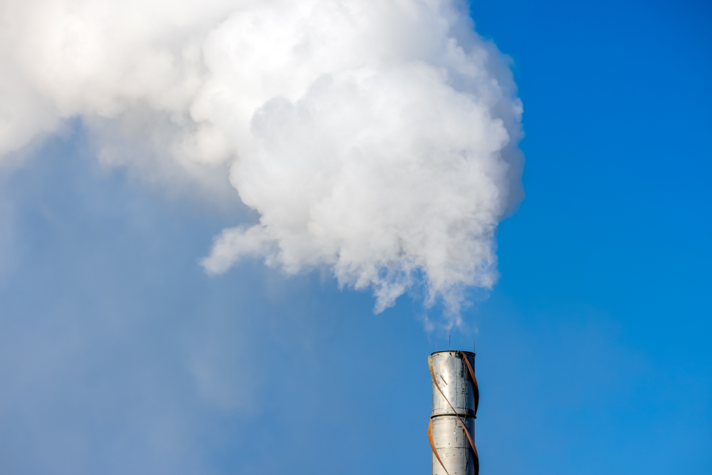 Aerial view of cement factory and smoke in chimney in industrial production area.