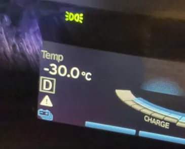 Close-up of an electric vehicle's display showing an outside temperature of -30C.
