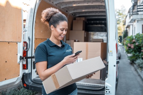 female delivery worker with van and packages