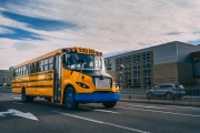 Lion electric school bus by school building