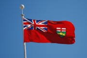 The Ontario flag with blue sky behind