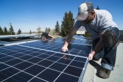 Workers installing solar panels on a residential homes roof