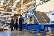 Group of workers huddled together in discussion inside a solar panel facility