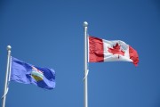The flags of Alberta and Canada fly beside each other.