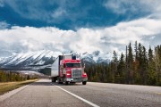 A Semi Truck Drives on Highway in the Canadian Rockies, Alberta, Canada.